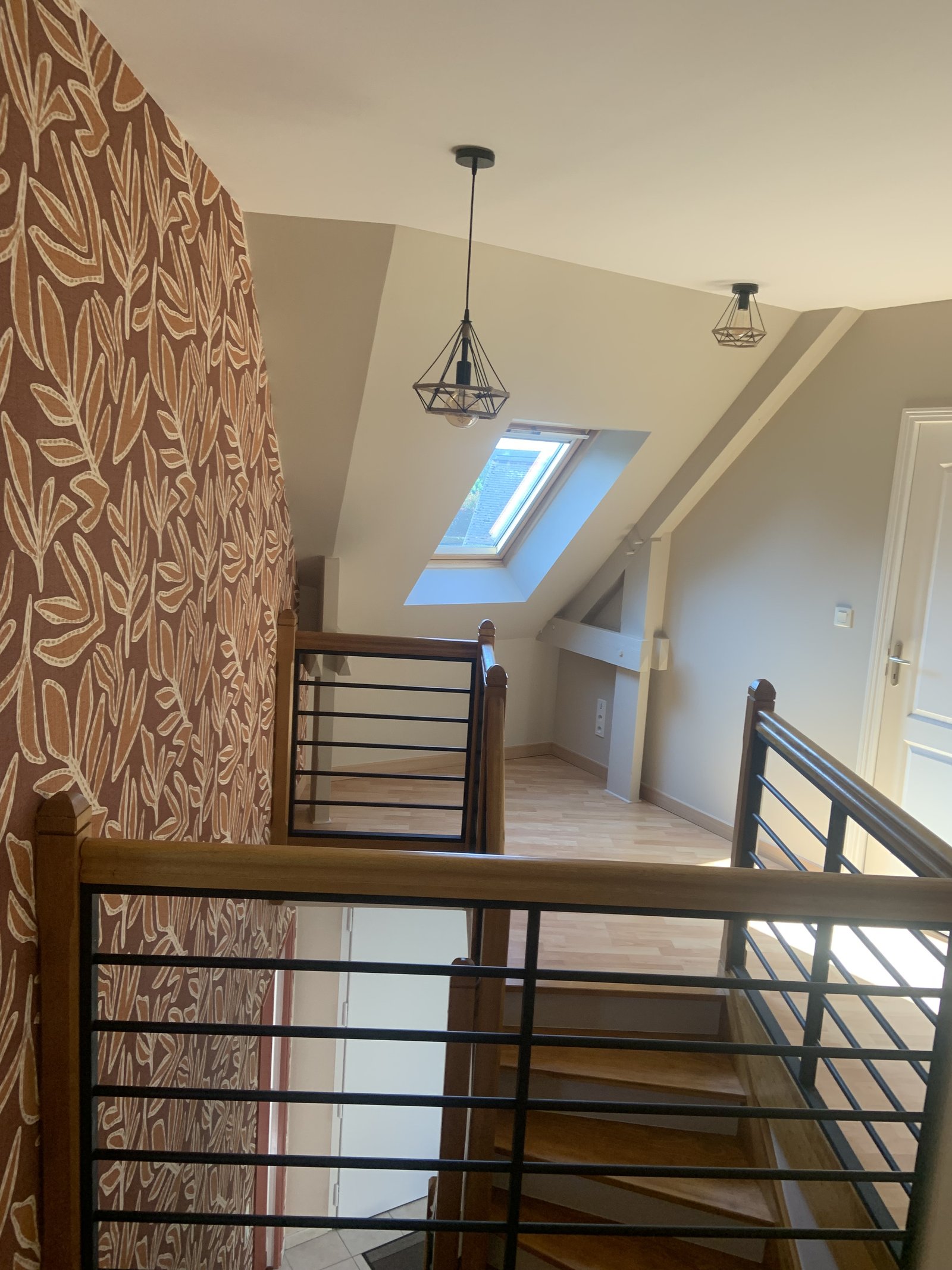 Papier peint terracotta dans cage d'escalier avec rambarde bois